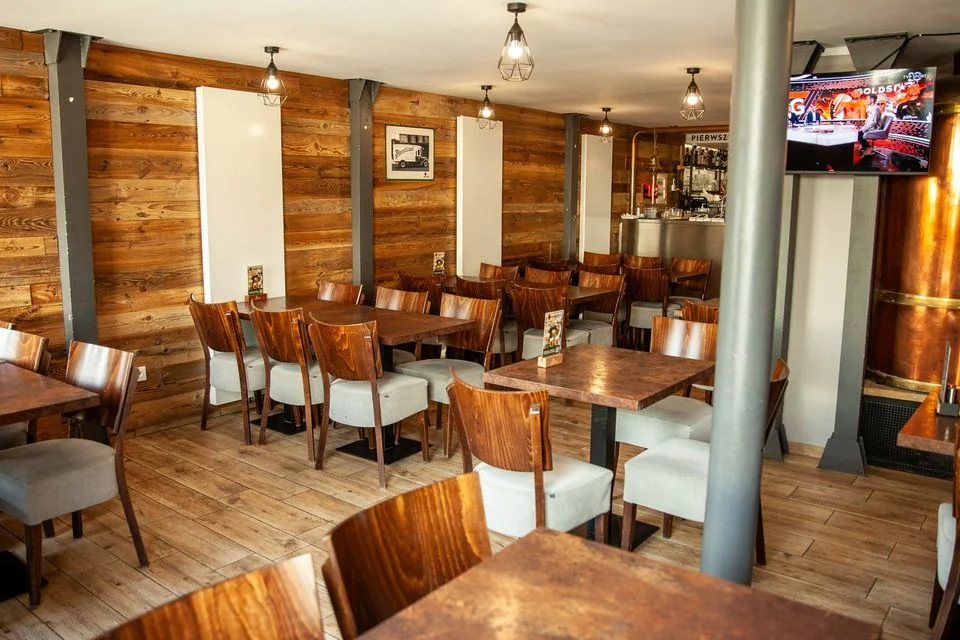 Sala z drewnianą ścianą i tankiem Pilsner Urquell – Pyšná Chalupa