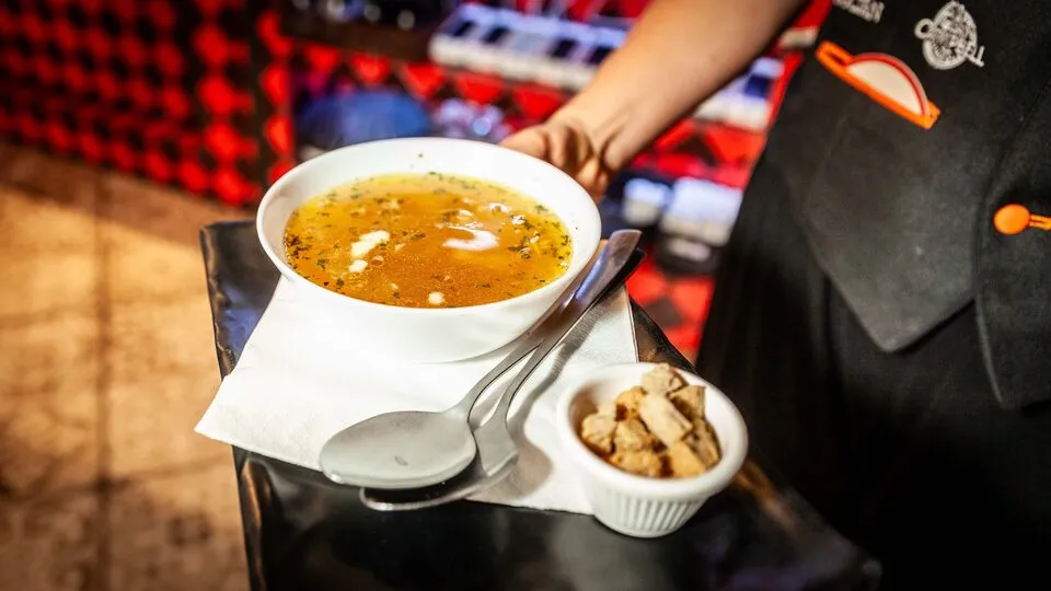 Zupa czosnkowa česnečka podawana przez kelnera – Dřevný Kocúr